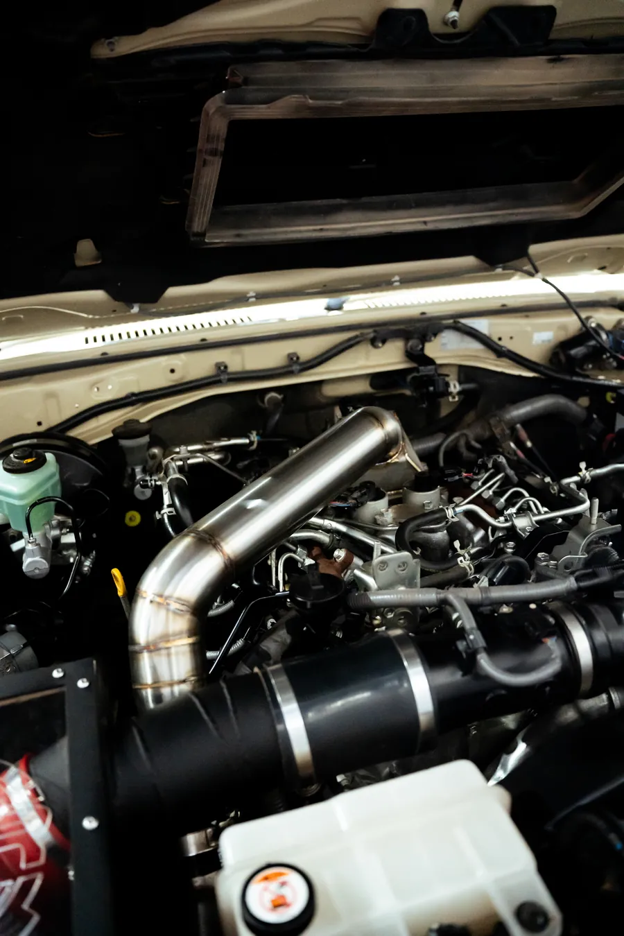Beige Land Cruiser 79 engine bay with intercooler piping