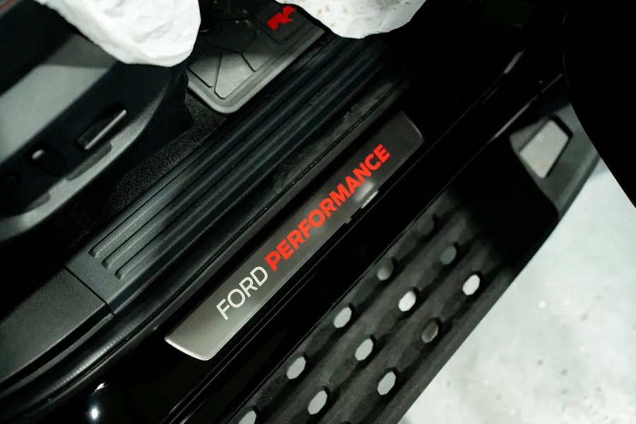 A gloved hand wiping a Ford Performance sill plate