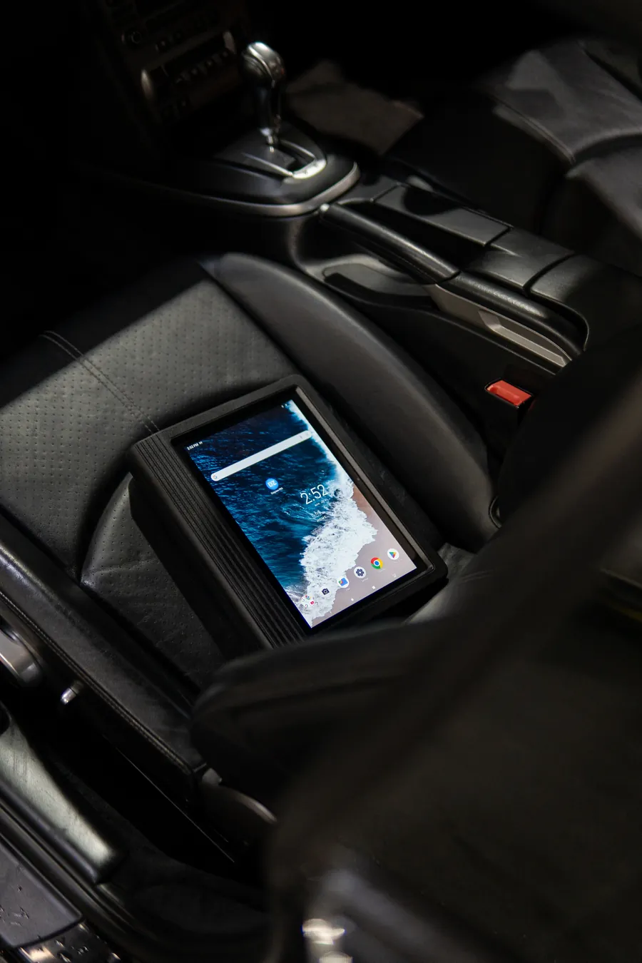 A diagnostic tablet connected inside a car in the workshop